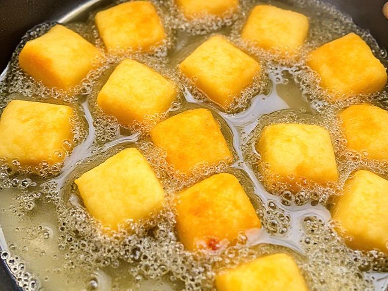 Corn nuggets frying in hot oil until golden brown and crispy – homemade restaurant-style snack.